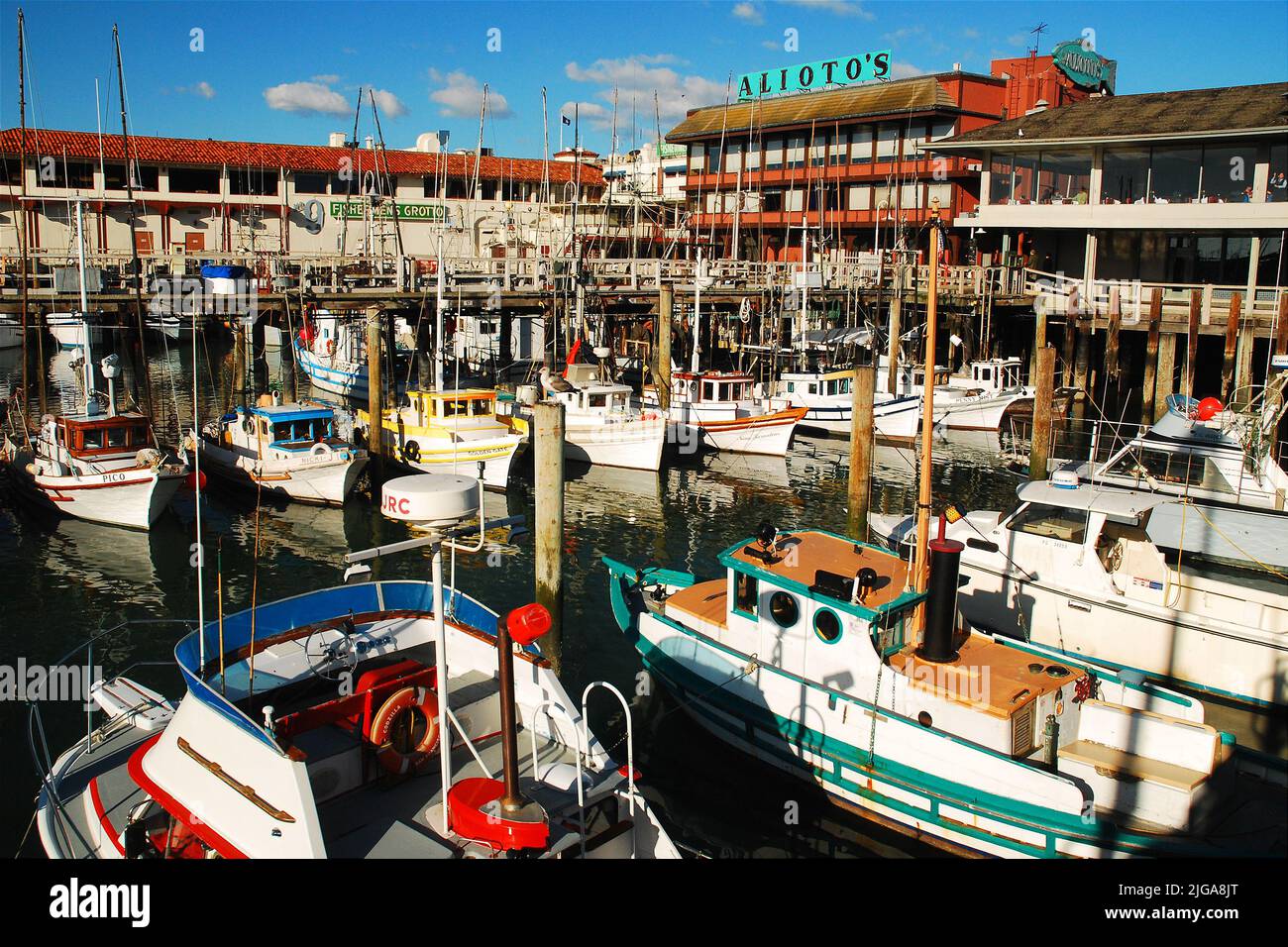 In San Franciscos Fisherman's Wharf, einer beliebten Touristenattraktion, sind arbeitende Fischerboote und Ausflugsschiffe angedockt Stockfoto