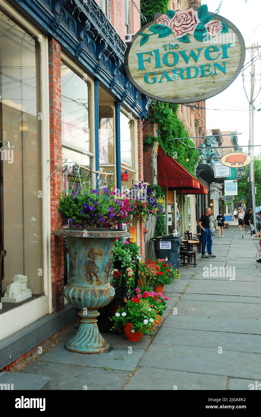 Auf den Gehwegen der Innenstadt von Saugerties, New York, zeigt ein Blumengeschäft und ein Souvenirladen ihr Handwerk. Die Stadt gilt als eine der coolsten Kleinstädte Stockfoto