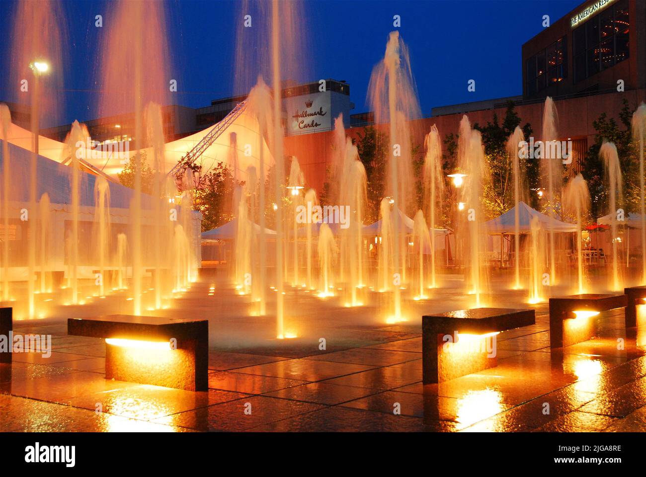 Wasserfontänen des Crown Plaza in Kansas City Missouri werden in der Dämmerung beleuchtet und spiegeln sich im nassen Boden des plaza wider Stockfoto