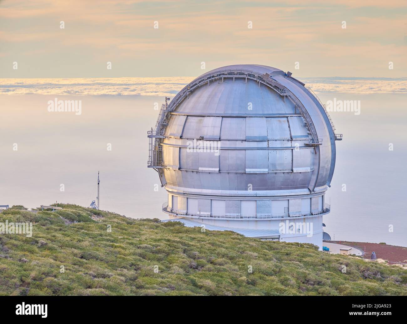 Nahaufnahme eines astronomischen Observatoriums mit klarem Himmel und Kopierraum. Fernrohr, umgeben von viel Grün und auf einer Insel am Rande einer Klippe gelegen Stockfoto