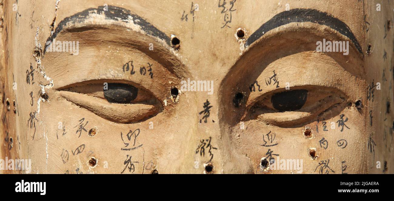 Vintage Buddha-Gesicht aus Holz mit angedeuteten Akupunkturpunkten und Namen Stockfoto