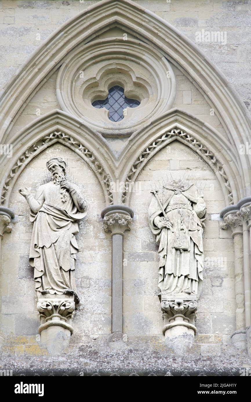 Ein Duo von Statuen, eine kopflos, an der Westfront der christlichen Kathedrale aus dem 13. Jahrhundert in Salisbury, England. Stockfoto
