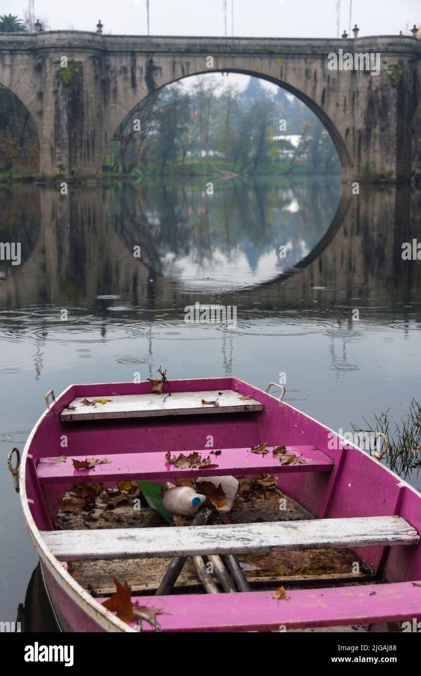 Rosa Ruderboot auf dem Fluss Tamega in der Nähe der historischen Brücke von Amarante, Portugal. Stockfoto