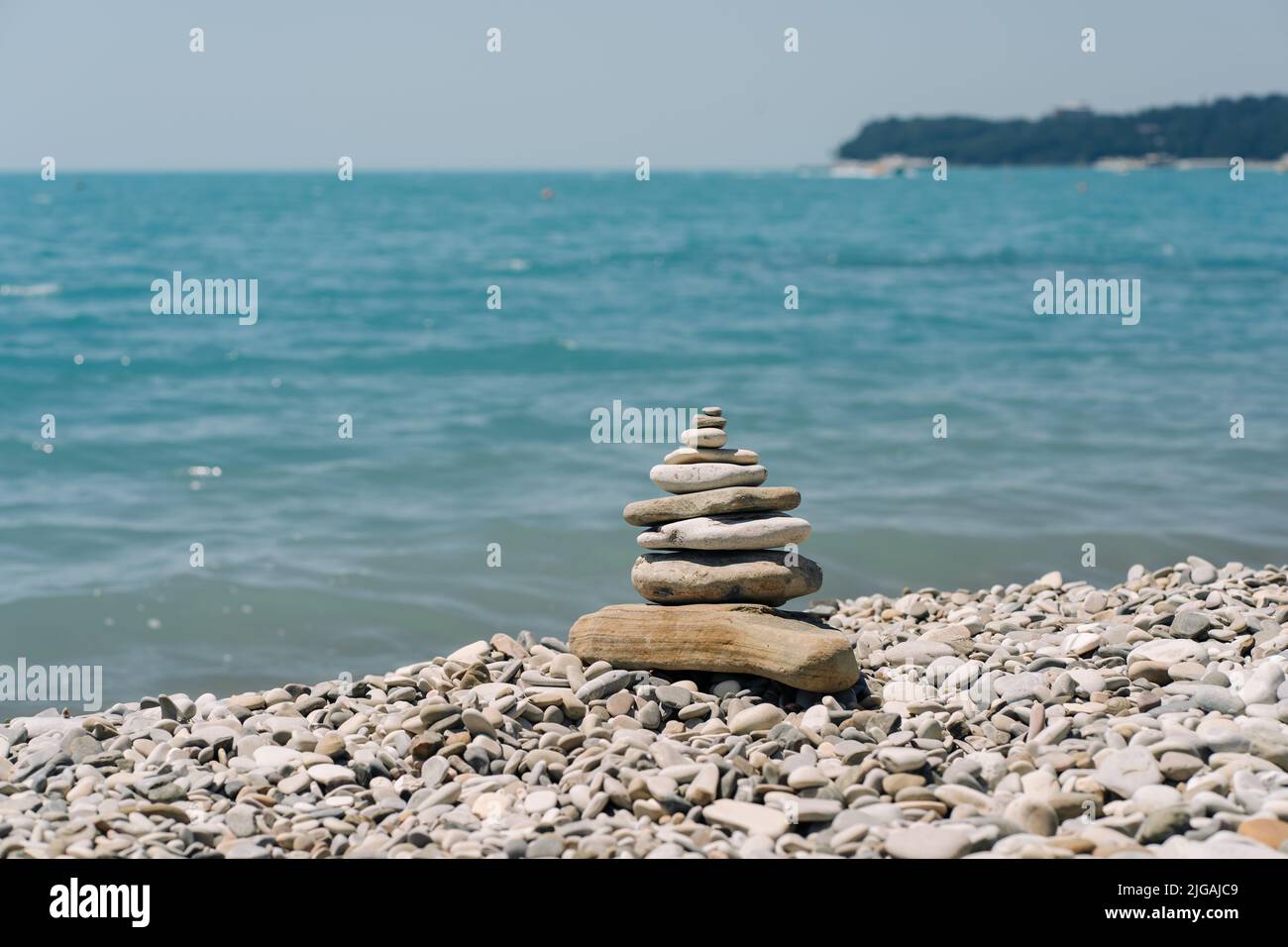 Ausgewogene Steine an einem Kieselstrand. Am Strand in einer Balancepyramide angeordnete Seesteine. Stockfoto