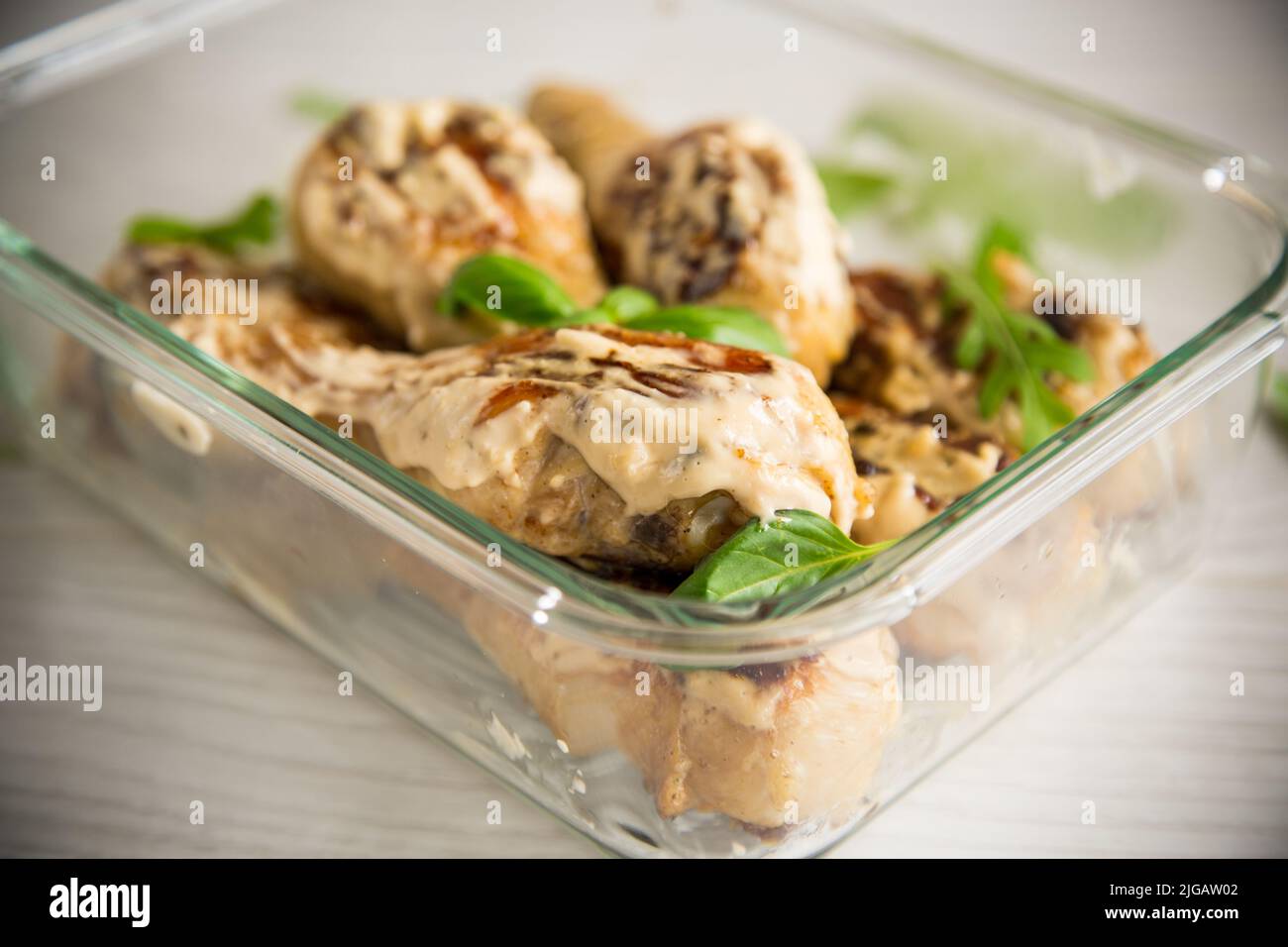 Gegrillte Hähnchenschenkel mit Gewürzen und Kräutern in Knoblauchsauce gebraten Stockfoto