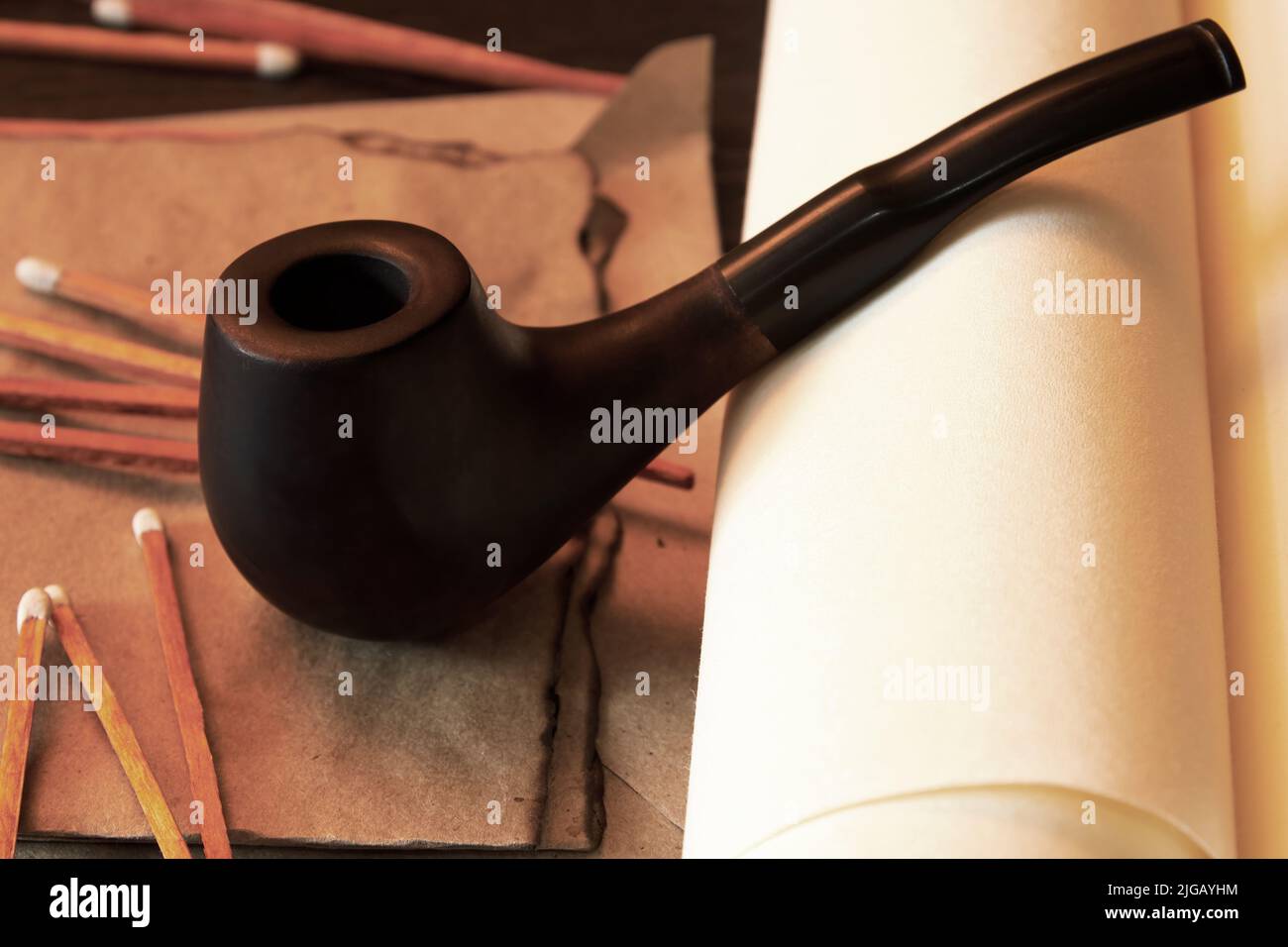 Retro Rauchrohr und Streichhölzer auf dem verbrannten letzteren und Papierrollen. Vintage Seemann Thema Bild Stockfoto