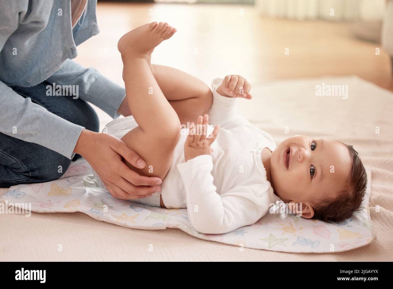 Mama weiß genau, was ich brauche. Eine Frau ändert ihre entzückende Baby Mädchen Windel zu Hause. Stockfoto