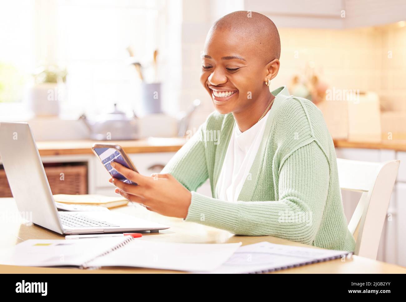 Die Online-Welt wartet auf Sie. Eine junge Frau nutzt ihr Smartphone, während sie von zu Hause aus arbeitet. Stockfoto