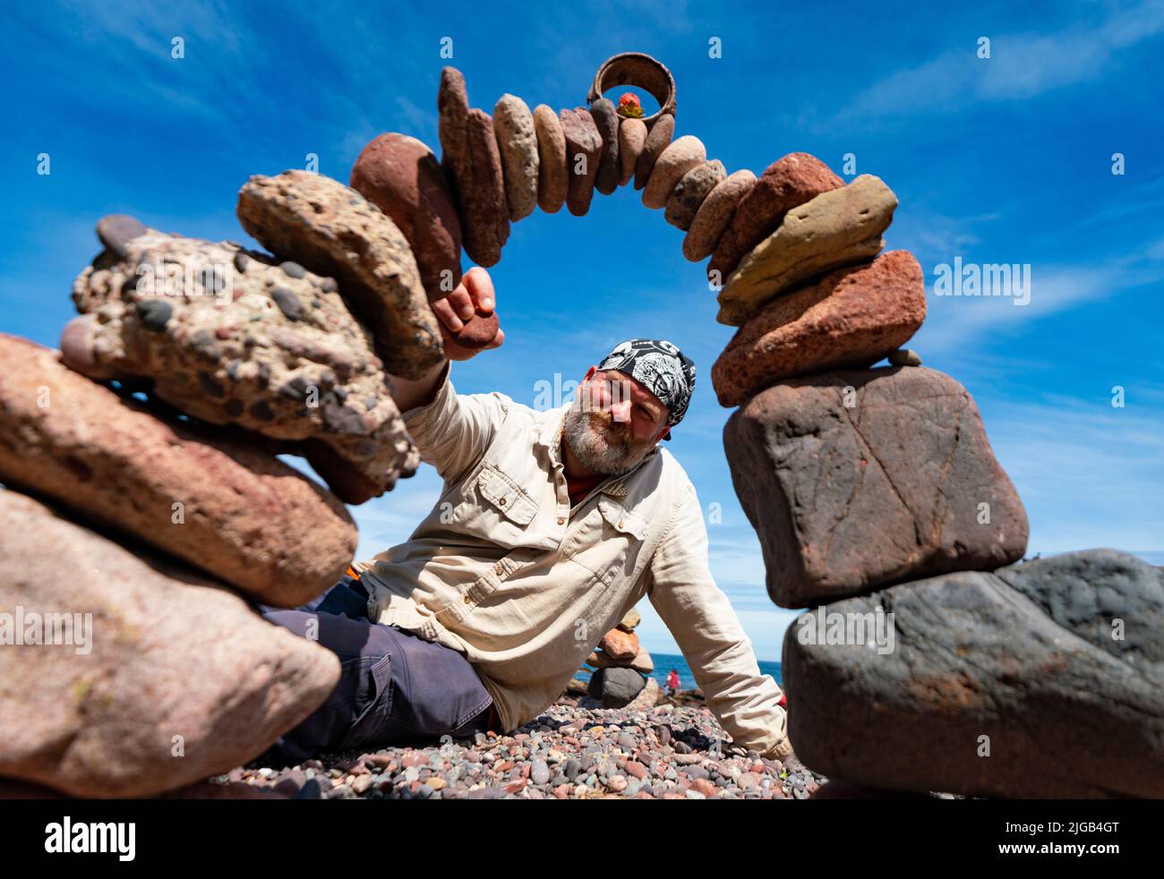 Dunbar, Schottland, Großbritannien. 9. Juli 2022. Tag eins der Stone Stacking Championships 11. am Eye Cave Beach in Dunbar in East Lothian. . Die Konkurrenz wird während des Wettkampfes im Bogenbau gezeigt. Bild; James Brunt baut seinen Steinbogen. Iain Masterton/Alamy Live News Stockfoto