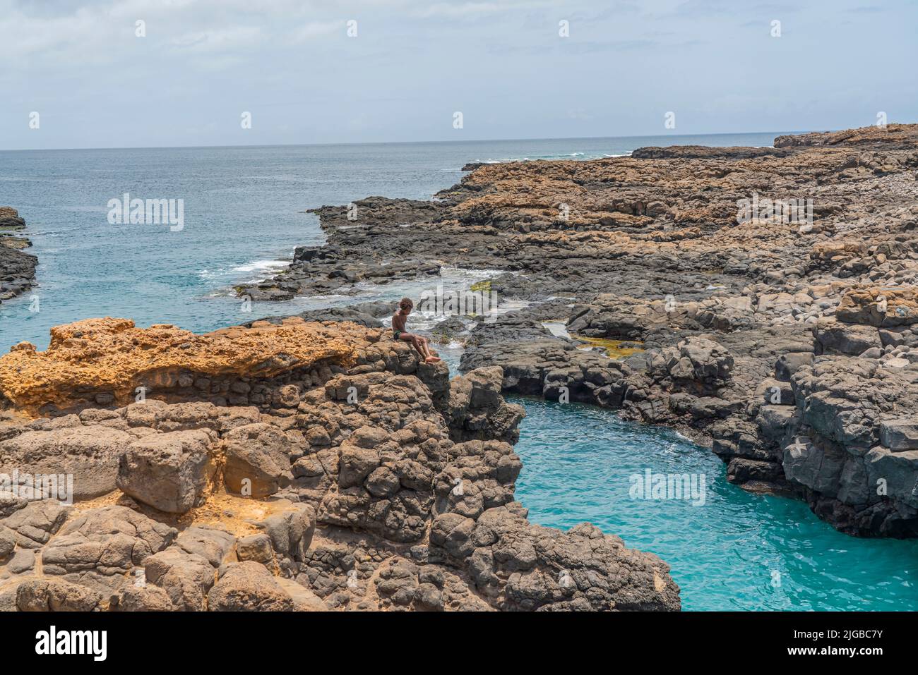 INSEL SAL, KAP VERDE - JUNI 22,2022: Buracona - das Blaue Auge von Cabo Verde, ein Junge an den Felsen Stockfoto