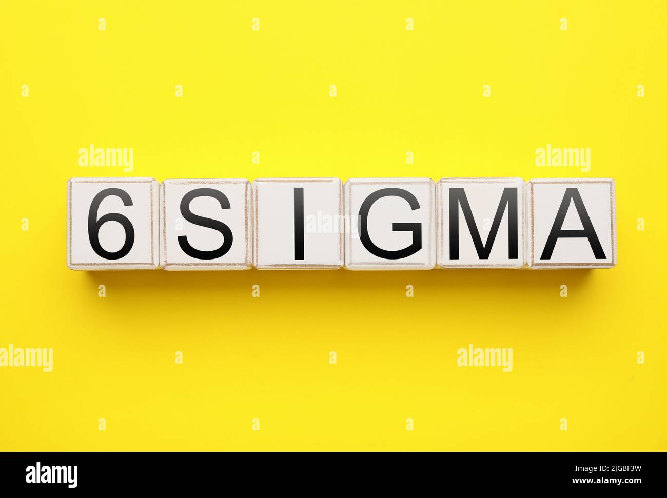 Würfel mit Text 6 SIGMA auf gelbem Hintergrund Stockfoto