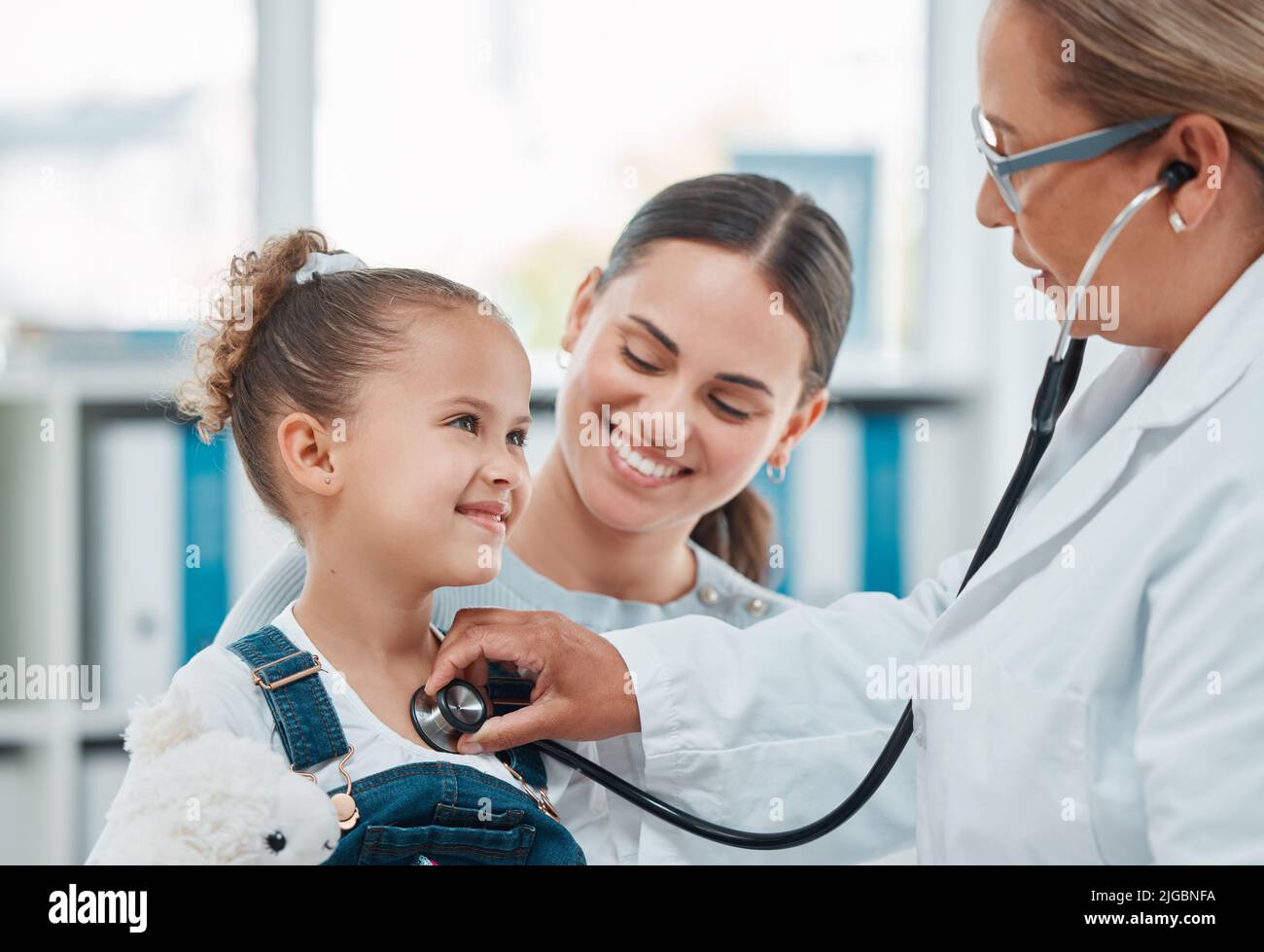 Ein Arzt untersucht ein kleines Mädchen mit einem Stethoskop in einer Klinik. Stockfoto