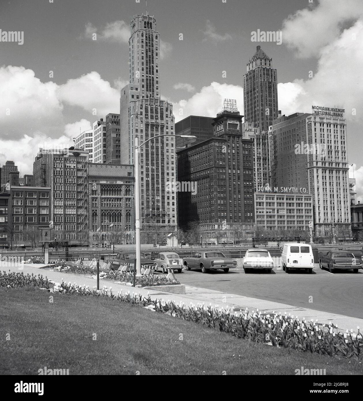 1960s, historisch, Blick aus dieser Ära der Himmelsschrecker auf der Michigan Avenue, Chicago, Illnois, USA. Der Möbelhändler J M. Smyth & Co, die Michigan Avenue National Bank und das Chicagoer Outlet von Almer Coe Opticians sind die berühmten amerikanischen Namen auf einigen Bürogebäuden. Stockfoto