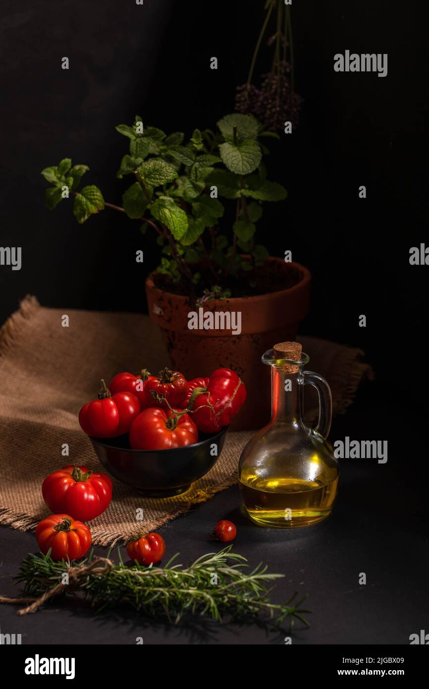 Bio-Gartentomaten zum Kochen mit Olivenöl, Knoblauch und Rosmarin Stockfoto