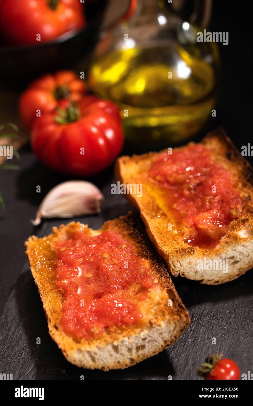 Traditionelle spanische Vorspeise - 'Pan Tomaca' (Brot mit Tomate) geröstetes Brot mit Knoblauch, gekrönt mit frisch gepressten Tomaten und nativem Olivenöl. Stockfoto