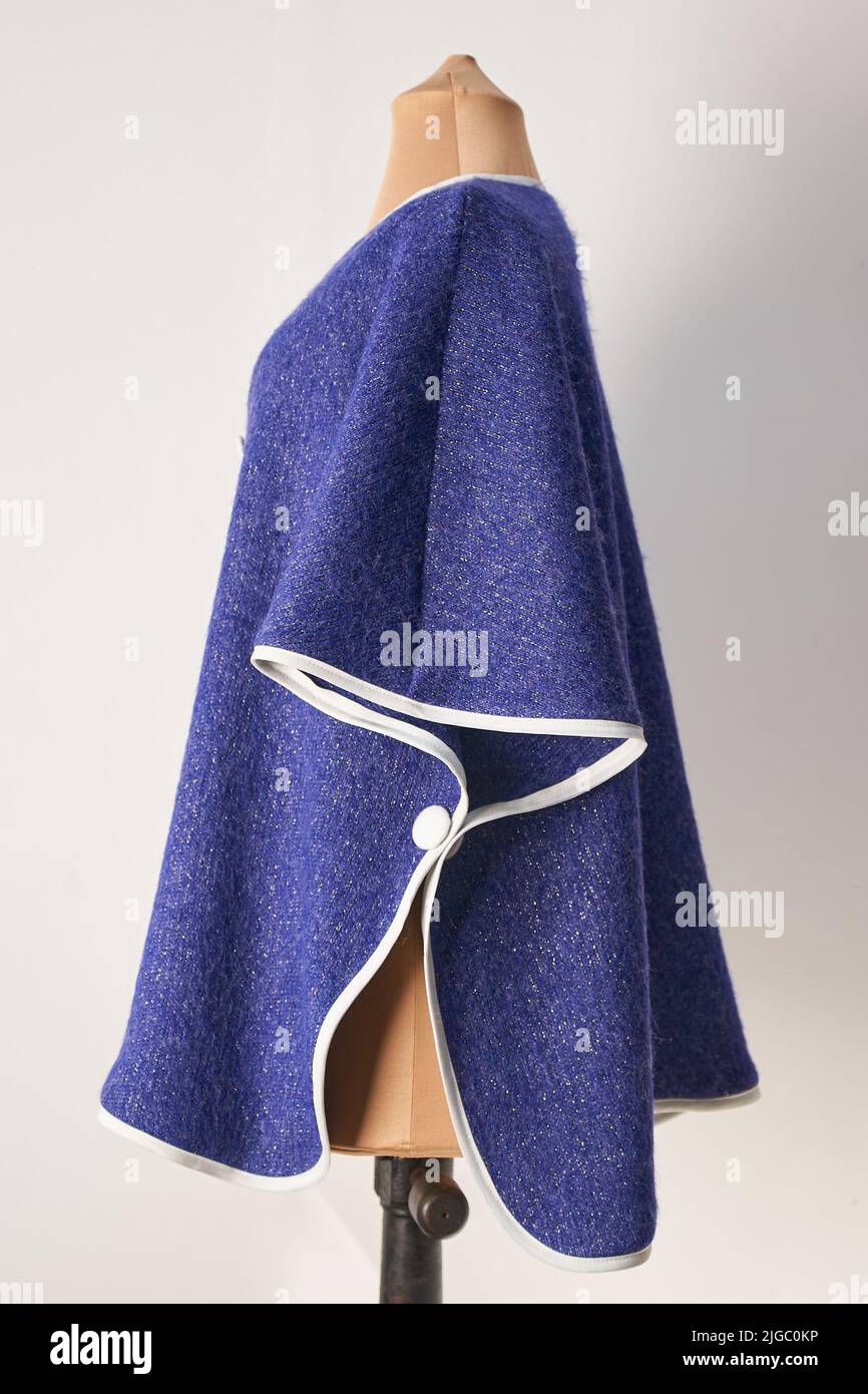 Poncho aus blauer Wolle mit weißen Applikationen. Formelle Damenbekleidung. Stockfoto