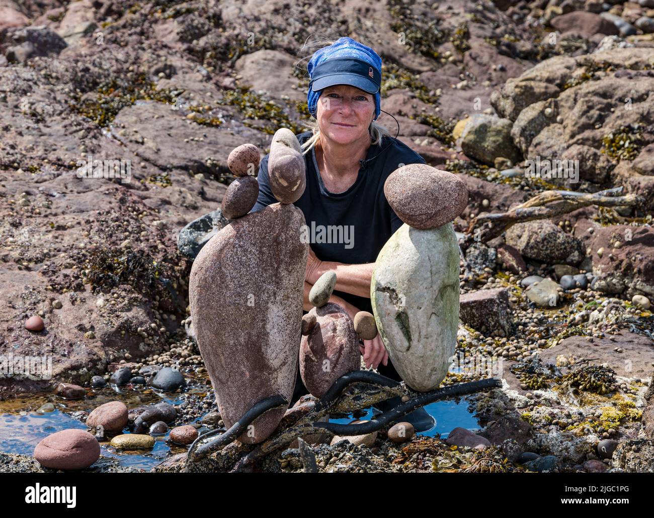 Dunbar, East Lothian, Schottland, Großbritannien, 9.. Juli 2022. European Stone Stacking Championship: Die Teilnehmer haben 3,5 Stunden Zeit, ein künstlerisches Kunstwerk aus den Felsen am Eye Cave Beach zu kreieren. Im Bild: Caroline Walker aus Edinburgh Stockfoto