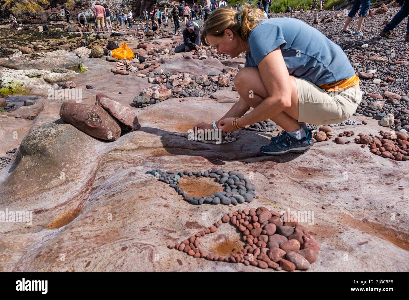 Dunbar, East Lothian, Schottland, Großbritannien, 9.. Juli 2022. European Stone Stacking Championship: Die Teilnehmer haben 3,5 Stunden Zeit, ein künstlerisches Kunstwerk aus den Felsen am Eye Cave Beach zu kreieren. Im Bild: Marianne Winter aus den Niederlanden, die diesen Wettbewerb 2019 gewann Stockfoto