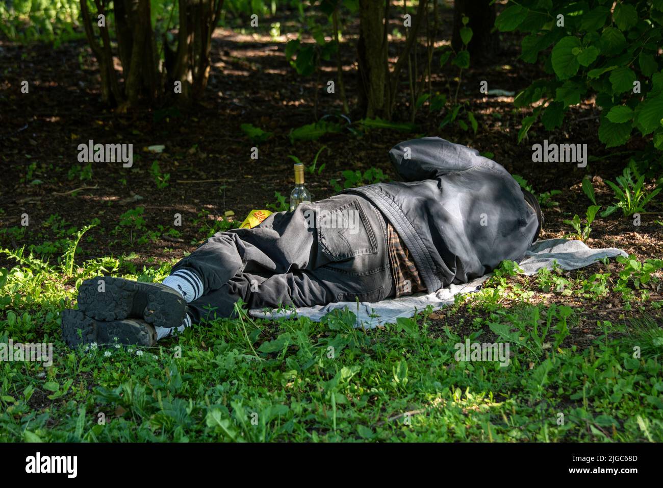 Alkoholischer oder obdachloser Mann, der im Park in Helsinki, Finnland, schläft Stockfoto