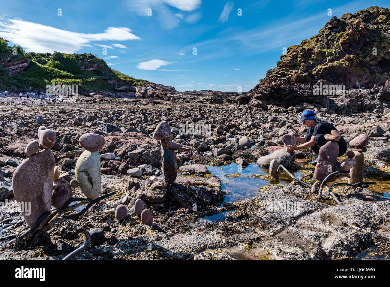 Dunbar, East Lothian, Schottland, Großbritannien, 9.. Juli 2022. European Stone Stacking Championship: Die Teilnehmer haben 3,5 Stunden Zeit, ein künstlerisches Kunstwerk aus den Felsen am Eye Cave Beach zu kreieren. Im Bild: Caroline Walker aus Edinburgh Stockfoto