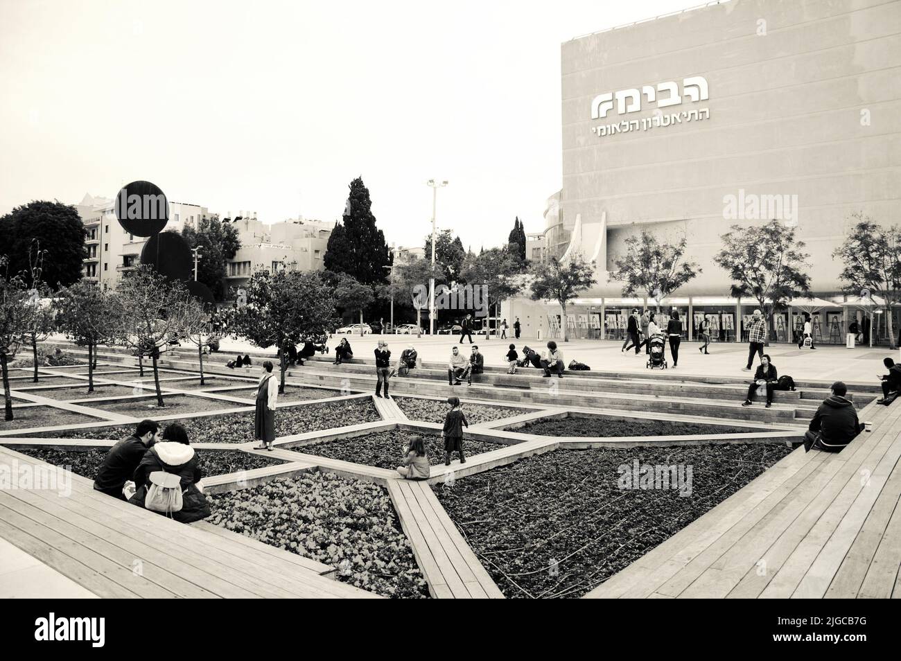 TEL AVIV, ISRAEL - 28. DEZEMBER 2017: Habima Theater Neubau und Menschen entspannen im Garten am Platz. Historisches Foto in Schwarzweiß Stockfoto