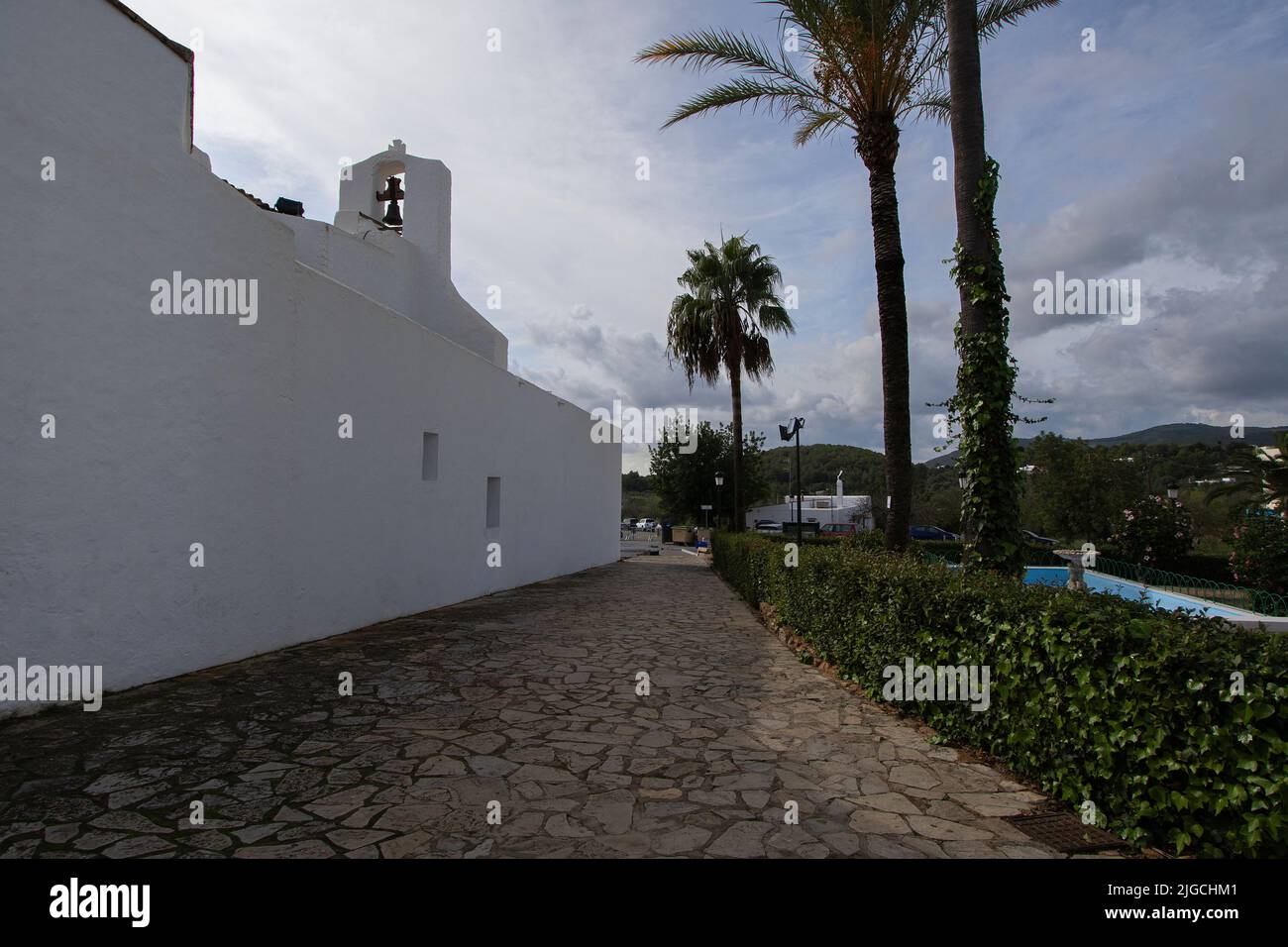 Schöne Landschaft von Himmel, Bergen und Vegetation von der Seitenfassade der Kirche Santa Eulalia auf Ibiza Stockfoto