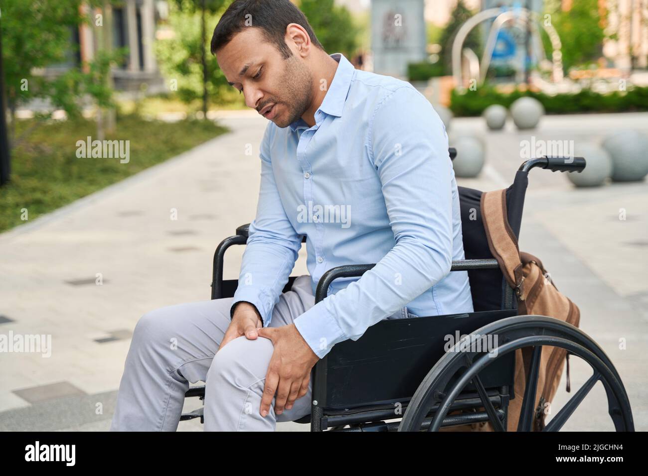 Behinderter Mann, der unter Beinschmerzen leidet Stockfoto