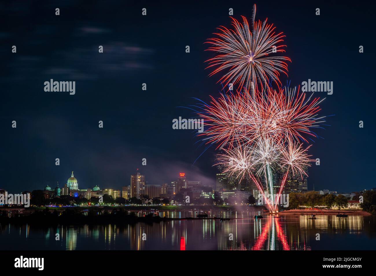 Harrisburg, Pennsylvania - 4. Juli 2022: Ein Blick auf das Feuerwerk vom 4.. Juli über der Stadt Harrisburg, das im Susquehanna River reflektiert wird. Stockfoto