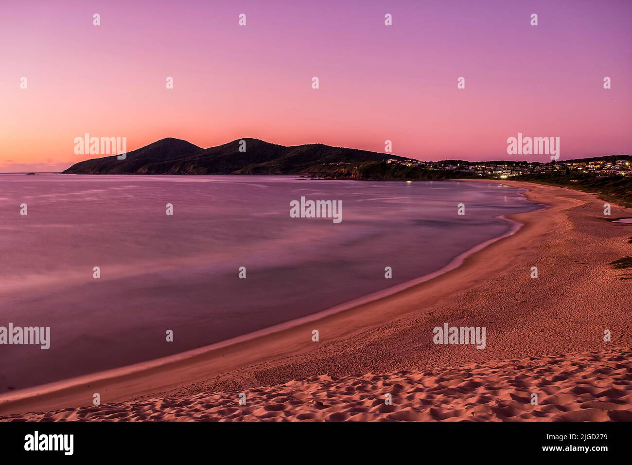 Die malerische Küste von One Mile Beach in der australischen Küstenstadt Forster bei rosa Sonnenaufgang. Stockfoto
