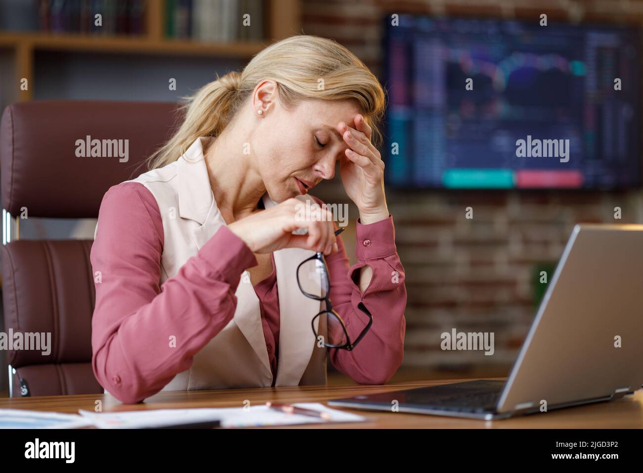 Depressive Geschäftsfrau überarbeitet auf Laptop-Computer. Müder Arbeiter erhielt schlechte Online-Nachrichten. Finanzkrise, Konkurs, Burnout-Syndrom Stockfoto
