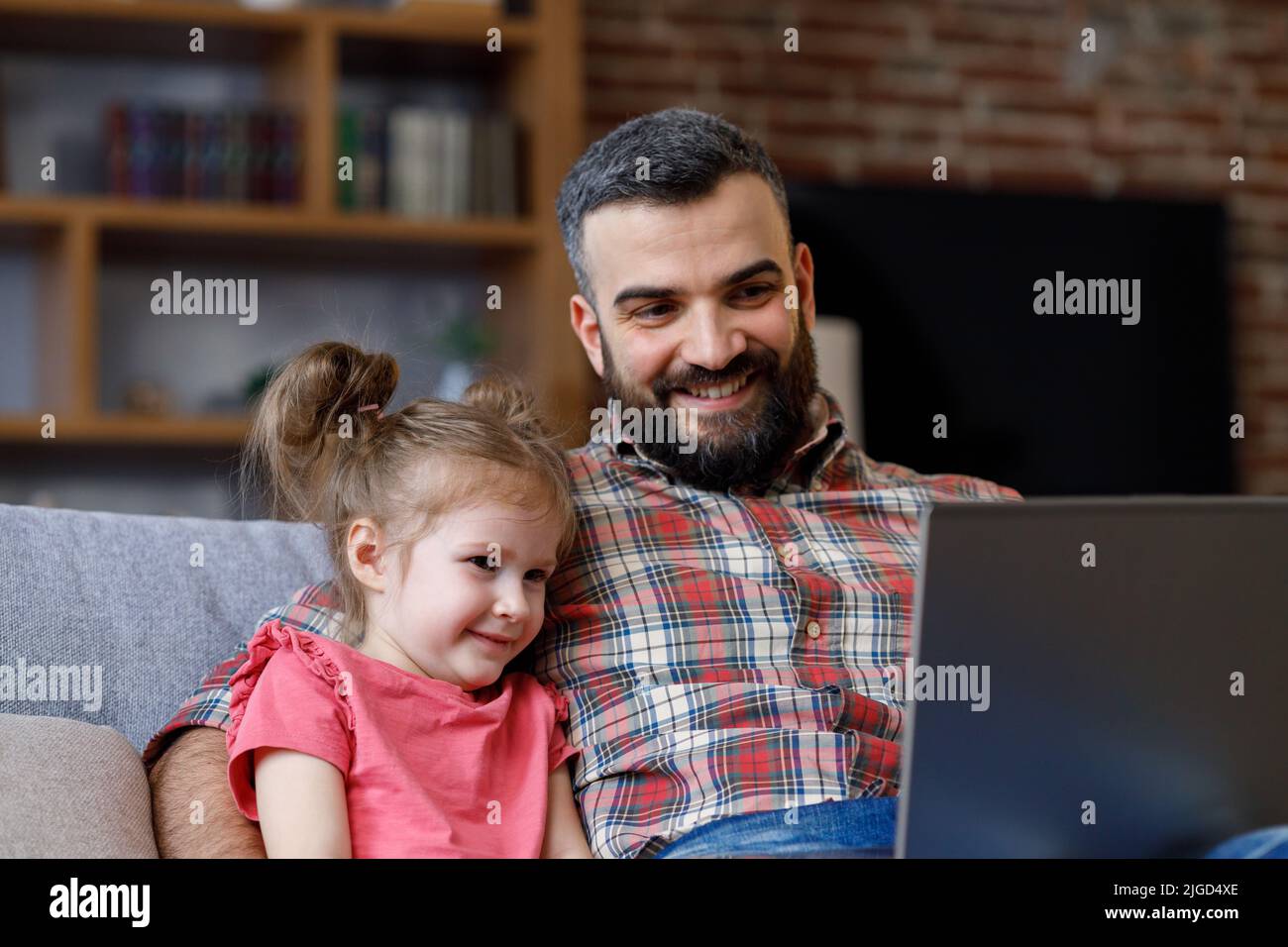 Vater und Tochter sehen lustige Videos und surfen online tv auf dem Laptop mit Lächeln Gesicht. Glückliche Familie Ruhen Sie sich im Bus mit Computer aus, genießen Sie die Zeit Stockfoto