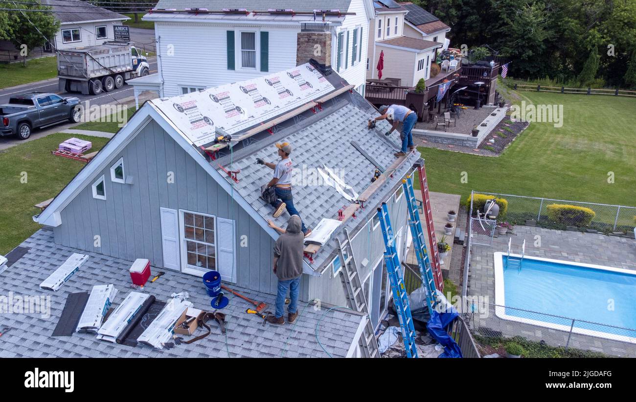 Dachdecker, die das Dach eines Hauses in Athen, Greene County, New York, USA, in Rente nehmen Stockfoto