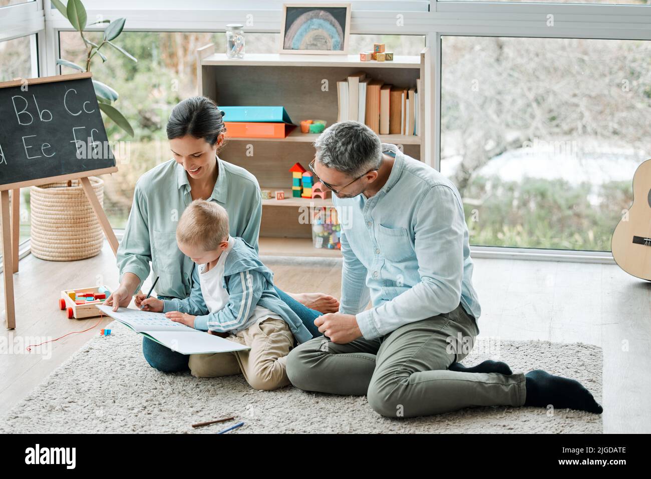 Familie ist keine wichtige Sache. Es ist alles. Zwei Eltern spielen mit ihrem Sohn zu Hause. Stockfoto