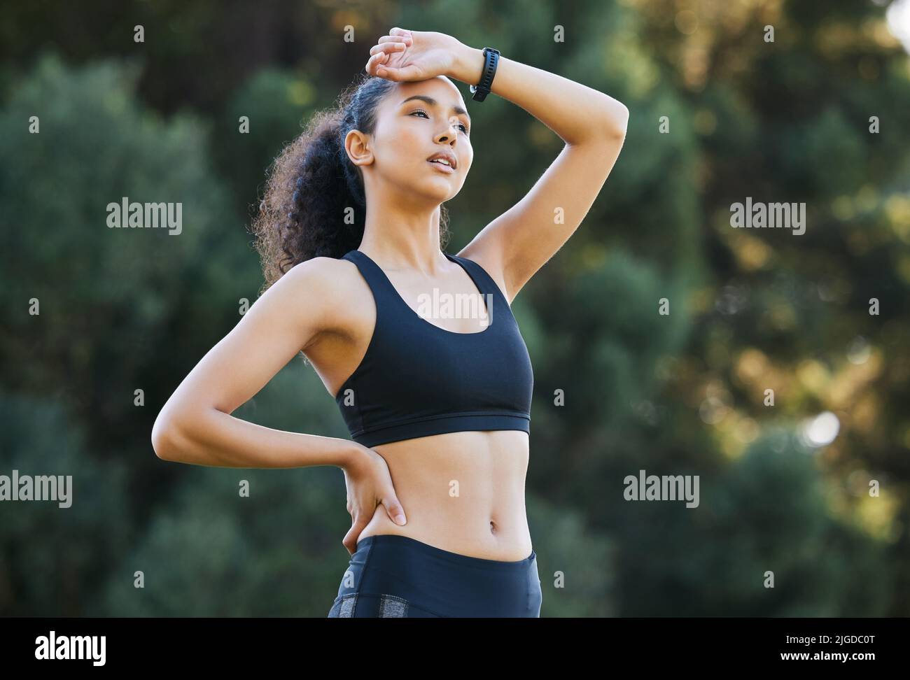 Puh, das war intensiv. Eine sportliche junge Frau atmet beim Training im Freien auf. Stockfoto