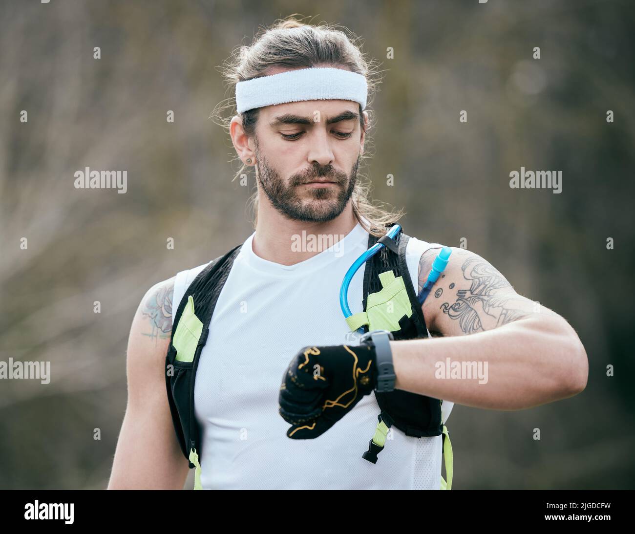 Das ist die Zeit zu schlagen. Ein hübscher junger Athlet überprüft die Zeit während seines morgendlichen Laufs. Stockfoto