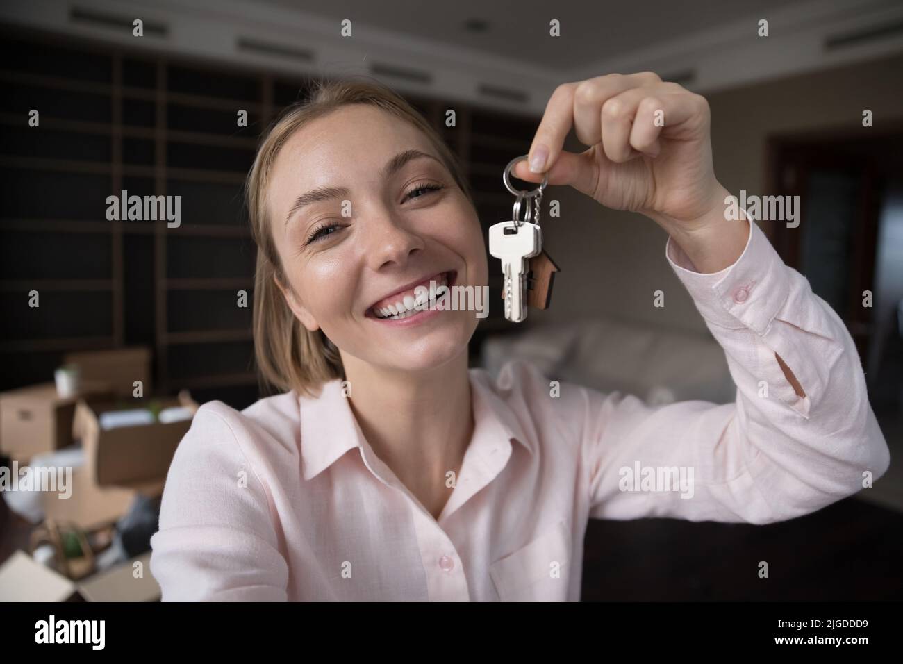 Glücklich fröhlich neue Hausbesitzer Mädchen hält, zeigt Schlüssel Stockfoto