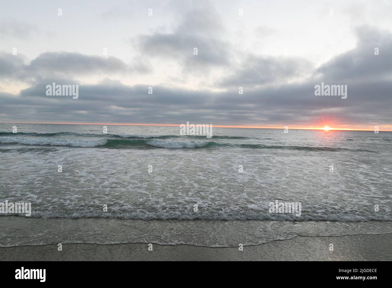 10. Juli 2022, San Diego, CA, USA: Die Korallen, Bäume, Felsen, Strand, Wellen, Orange Wolken und Meer während des glitzernden Sommeruntergangs in La Jolla, Kalifornien, am Samstag, den 9.. Juli 2022 (Bildquelle: © Rishi Deka/ZUMA Press Wire) Stockfoto
