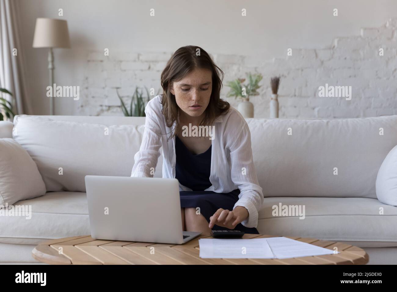 Junge Frau verwalten Finanzen mit Rechner, Rechnungen online bezahlen Stockfoto