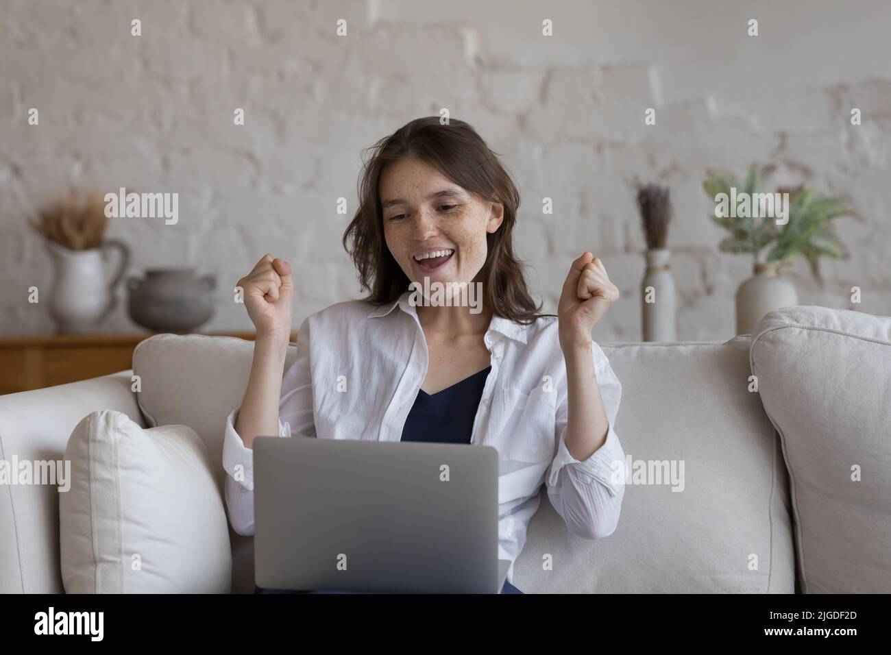 Frau schaut auf Laptop-Bildschirm lesen angenehme Nachrichten fühlt sich glücklich Stockfoto