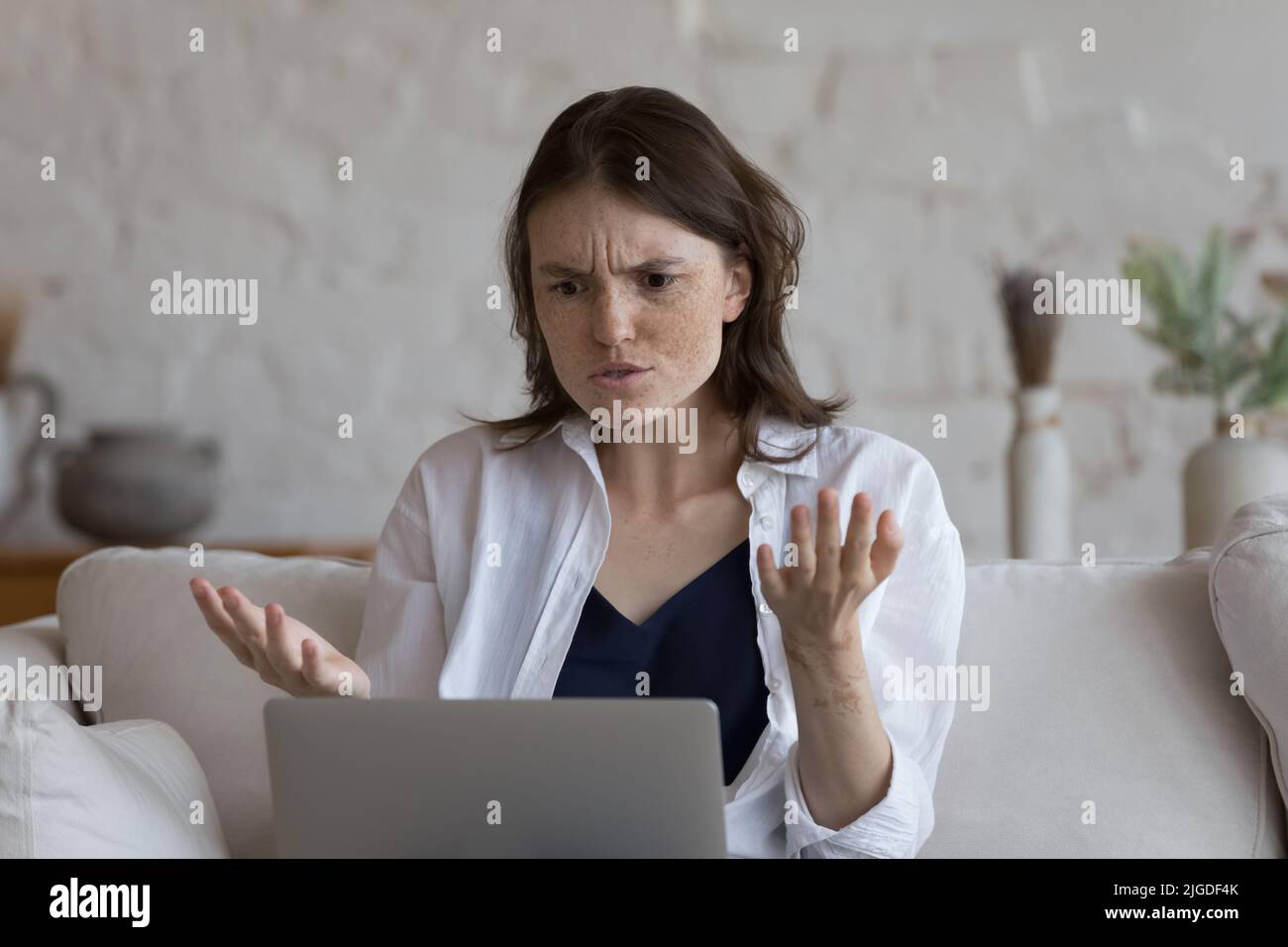Frau, die auf den Laptop starrt, fühlt sich aufgrund eines defekten Geräts wütend Stockfoto