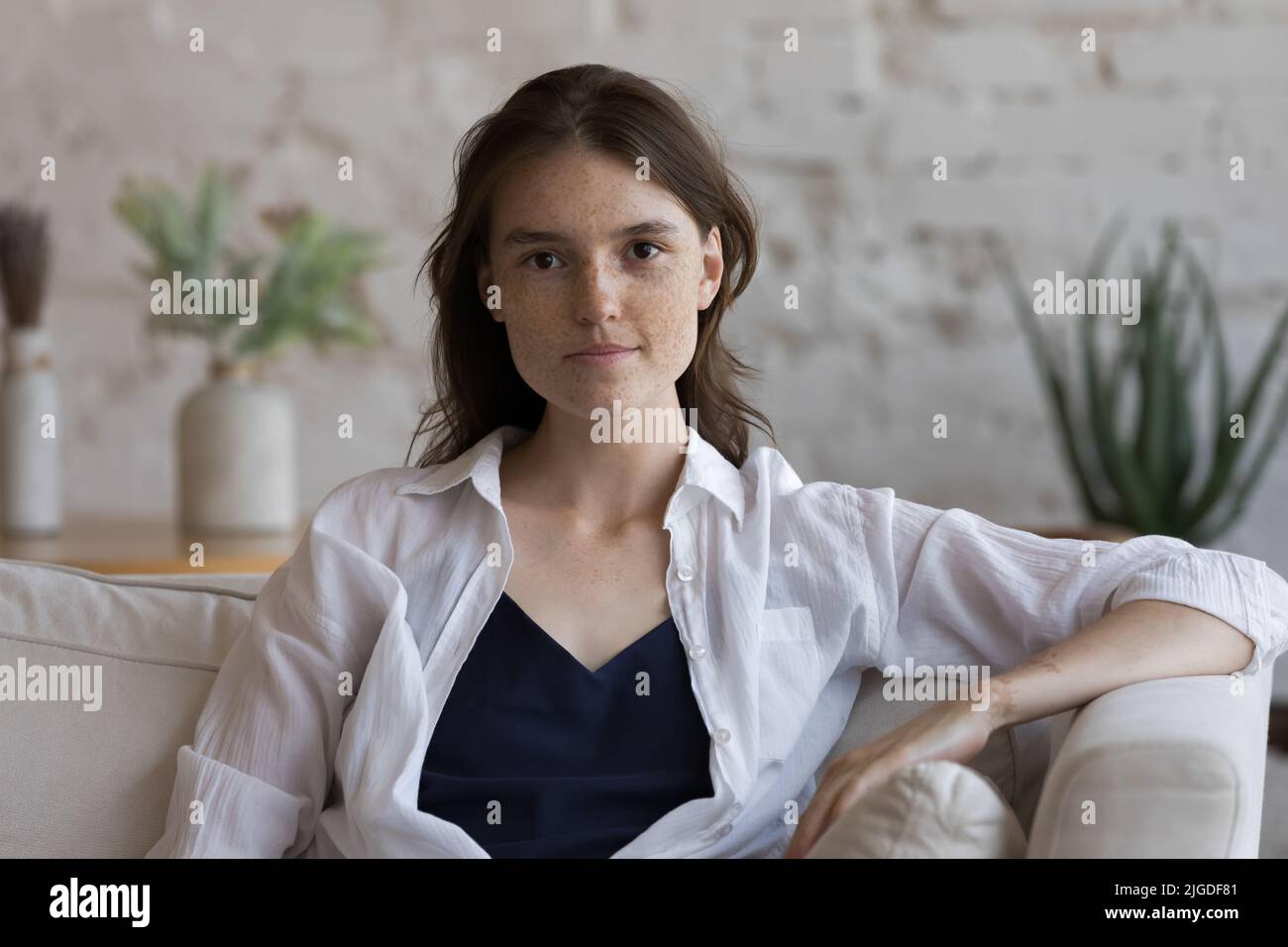 Headshot Portrait ernste Frau posiert auf der Kamera auf dem Sofa sitzend Stockfoto