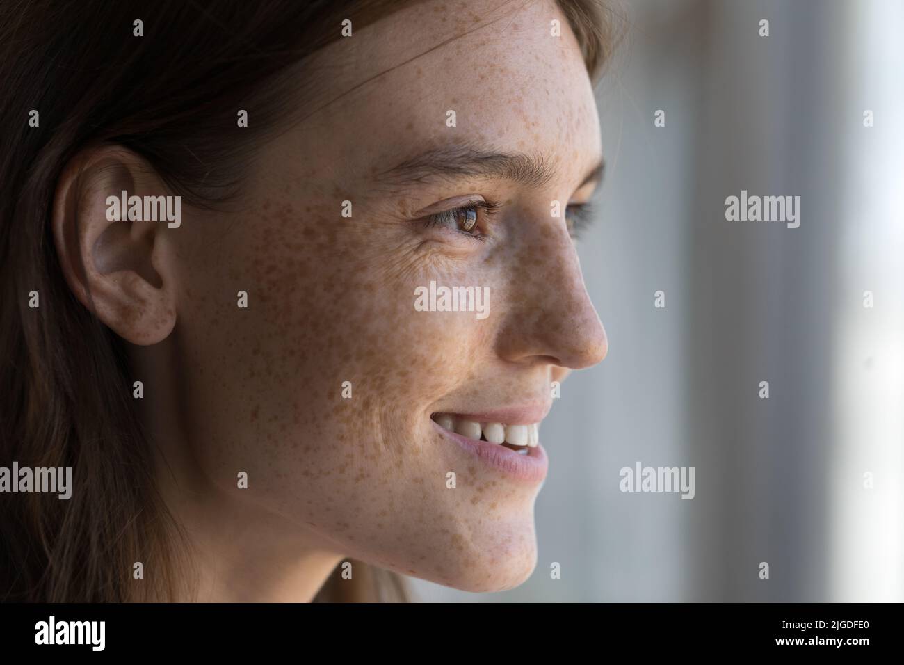 Profilansicht Gesicht einer jungen, in die Ferne starrenden Sommersprossen-Frau Stockfoto