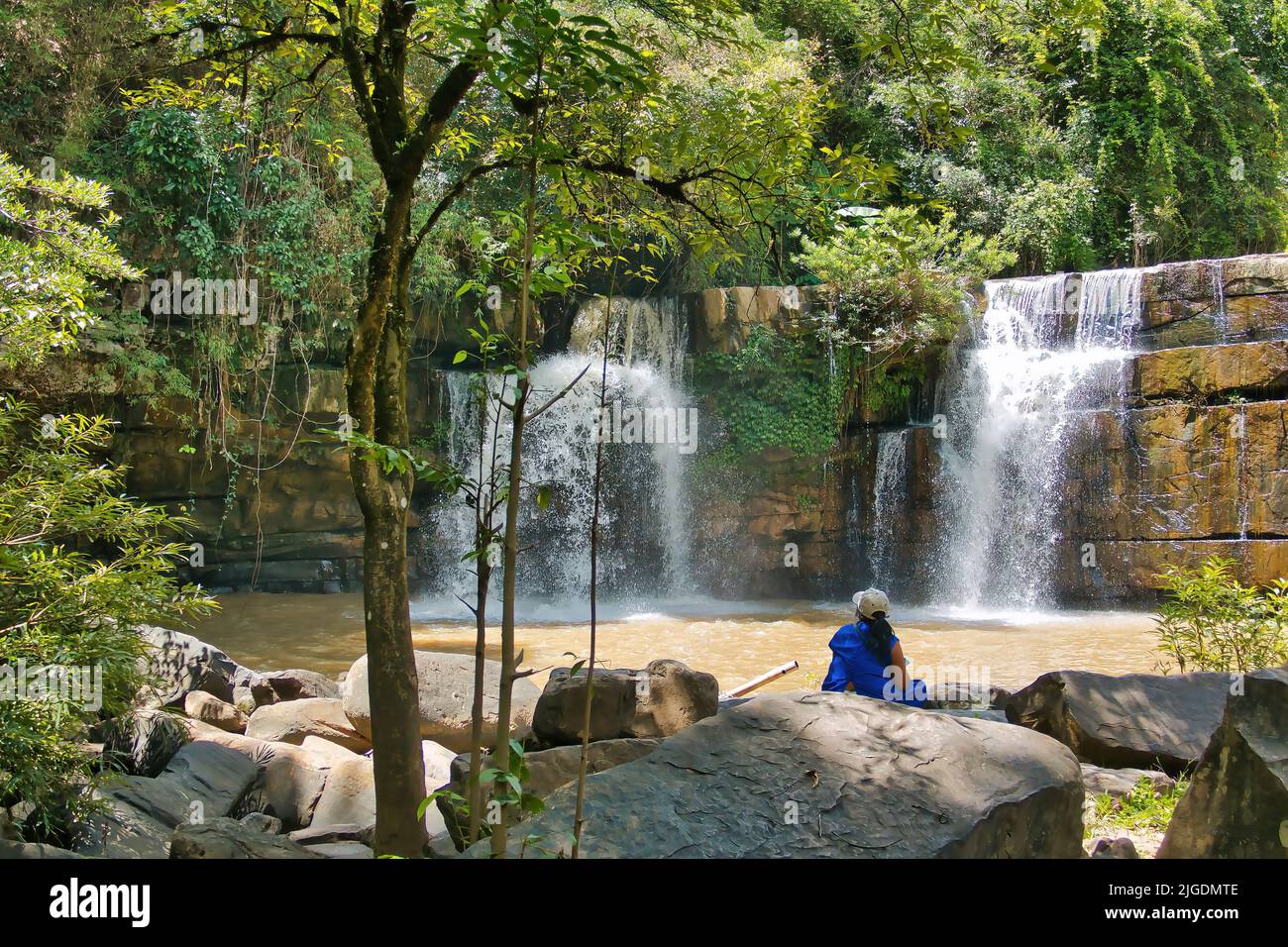 Nicht erkennbare Frau, die den Sri Dit Wasserfall im Dschungel des Nationalparks Khao Khao in Zentralthailand, Provinz Phetchabun, betrachtet Stockfoto