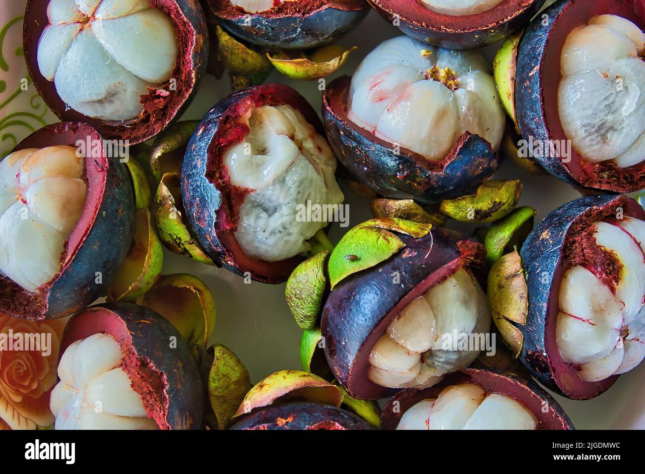 Nahaufnahme tropischer Mangostan-Früchte und Querschnitt aus violetter Haut und weißen Samen Stockfoto