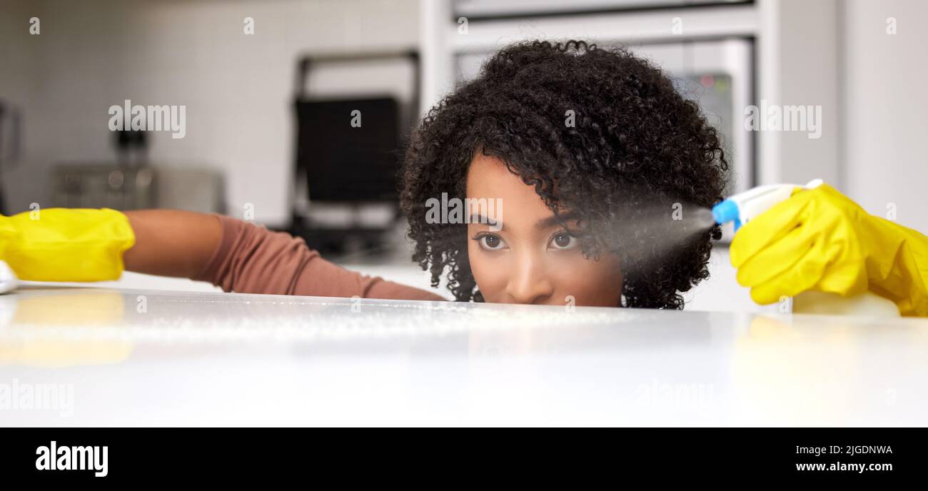 Sie können mich den Keimkiller nennen. Eine junge Frau, die zu Hause die Küchentheke putzt. Stockfoto