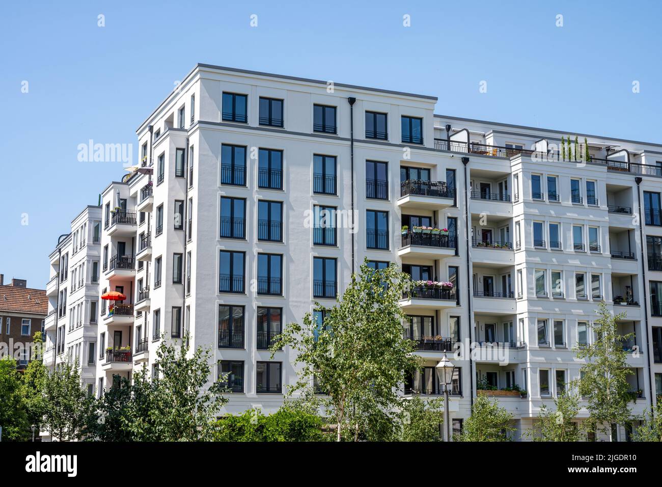 Modernes Apartmenthaus mit rotem Sonnenschirm in Berlin Stockfoto