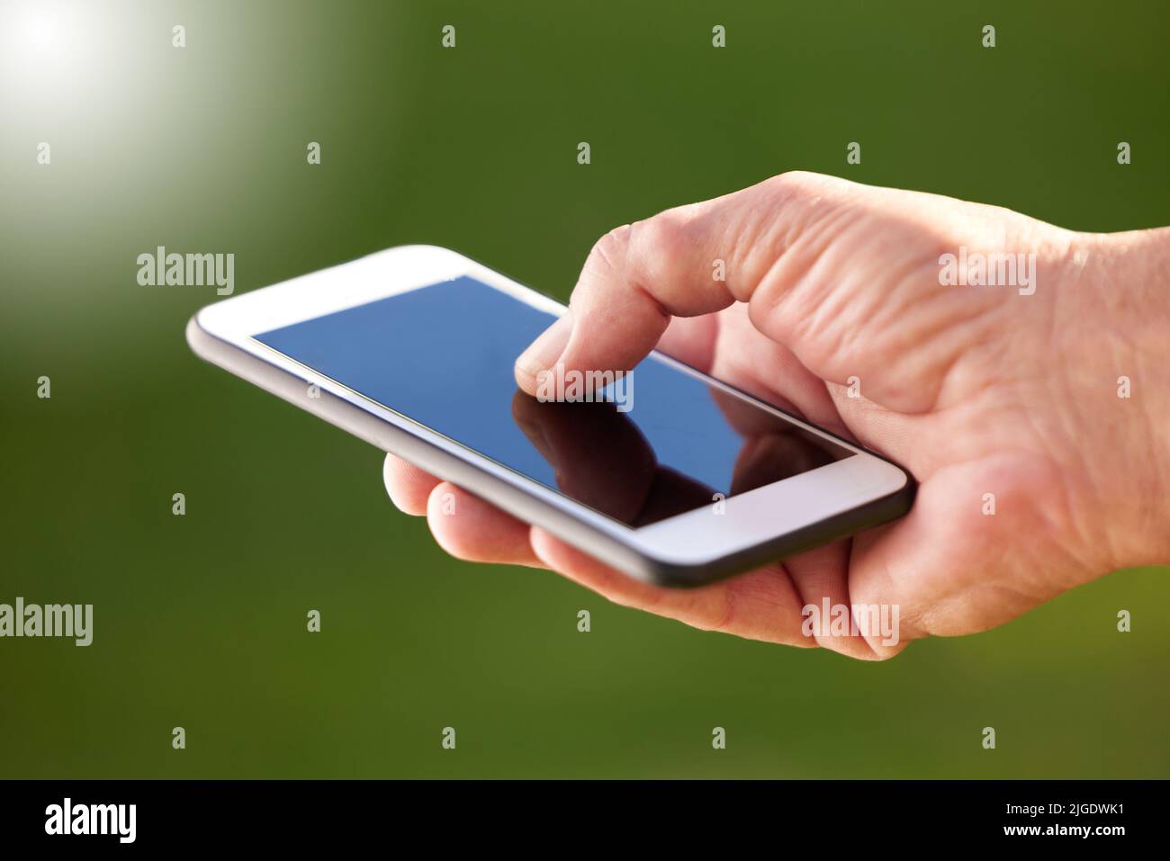 Anpassung an neue Technologie. Ein unkenntlich Mann, der sein Handy benutzt. Stockfoto