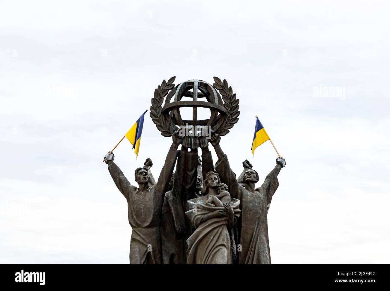 Die Bronzeskulptur „Weltfrieden“ in Hakaniemenranta, Helsinki, Finnland, mit ukrainischen Flaggen, die auf sie geklebt sind. Stockfoto