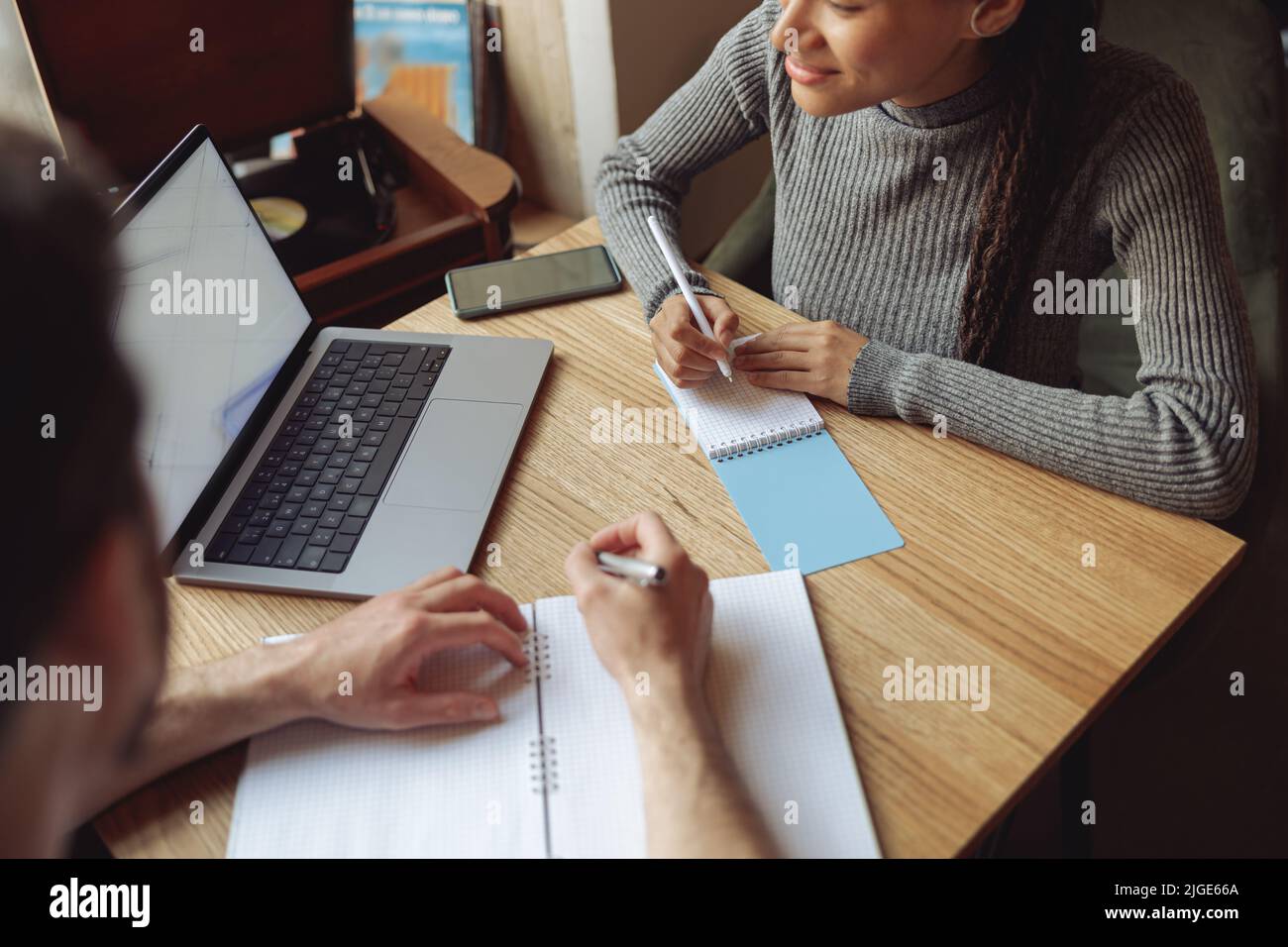 Ein paar Startupers mit Laptop und Notebooks beim Brainstorming beim Treffen im Café. Stockfoto