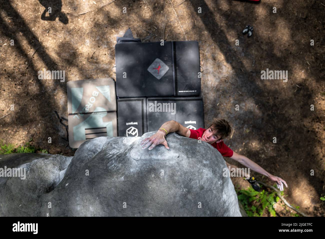 Der athletische junge Mann springt in einem berühmten und harten Dyno-Boulder namens „Cannon Ball -7b“ um Top Hold. Fontainbleau, Frankreich, Europa. Stockfoto